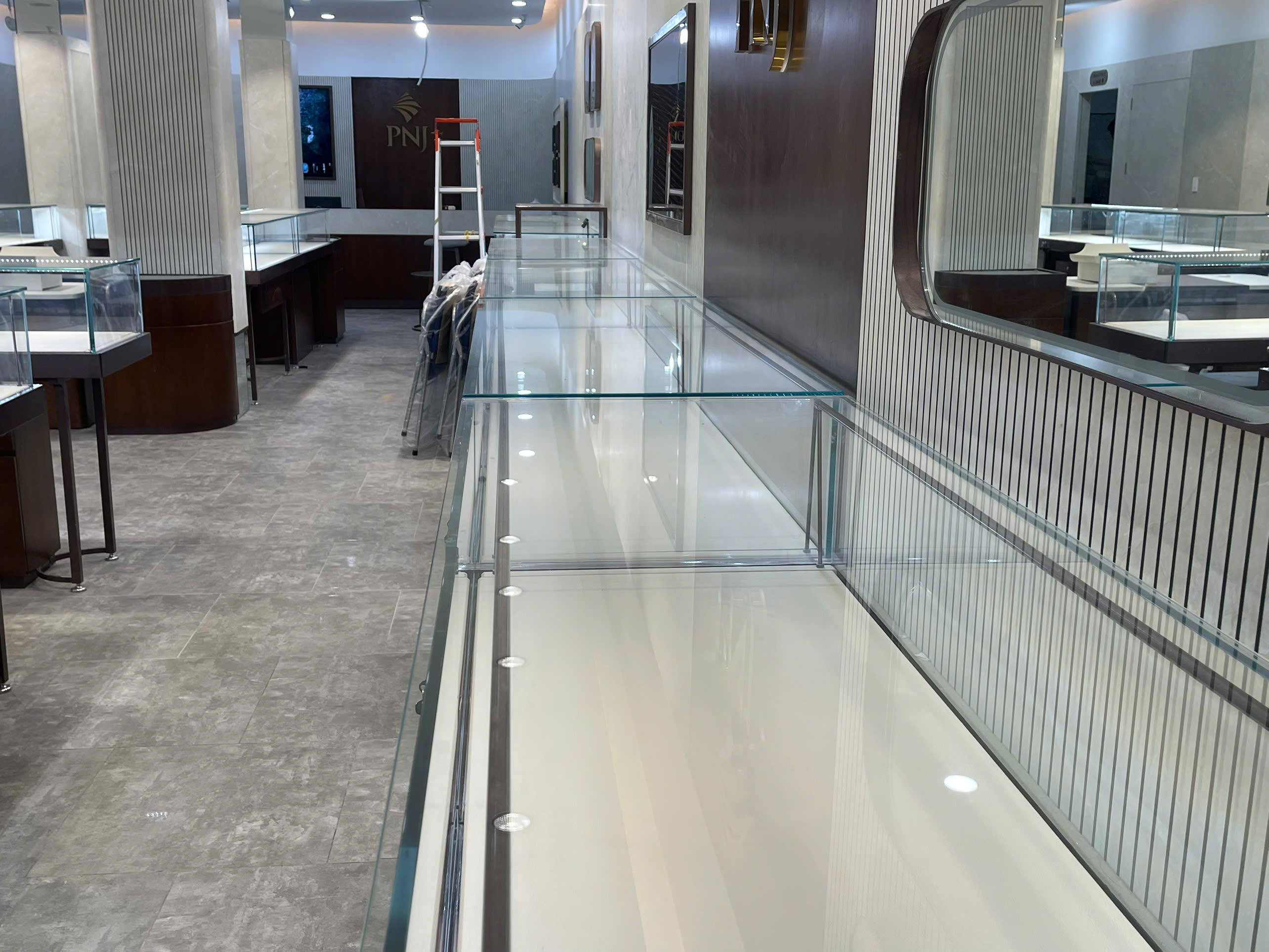 Hệ thống tủ kính trưng bày vàng trang sức tại cửa hàng PNJ với đèn LED chiếu sáng chuyên nghiệp