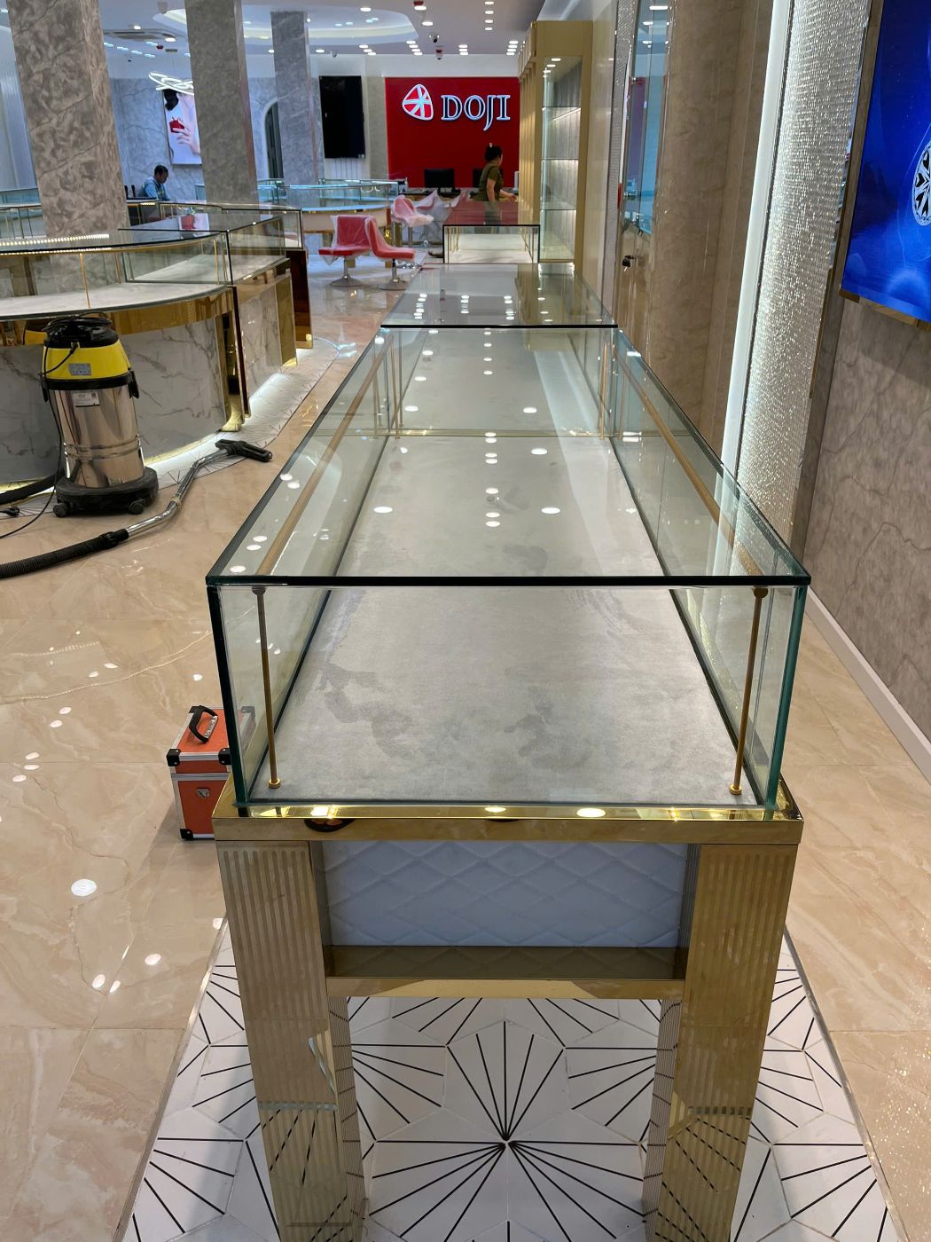 Đầu tủ kính dài chân inox vàng trong showroom trang sức
